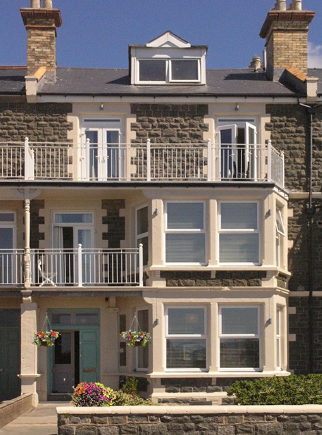 The front of The Arthur guest house on Marine Parade, with white balconies and flowers by the door